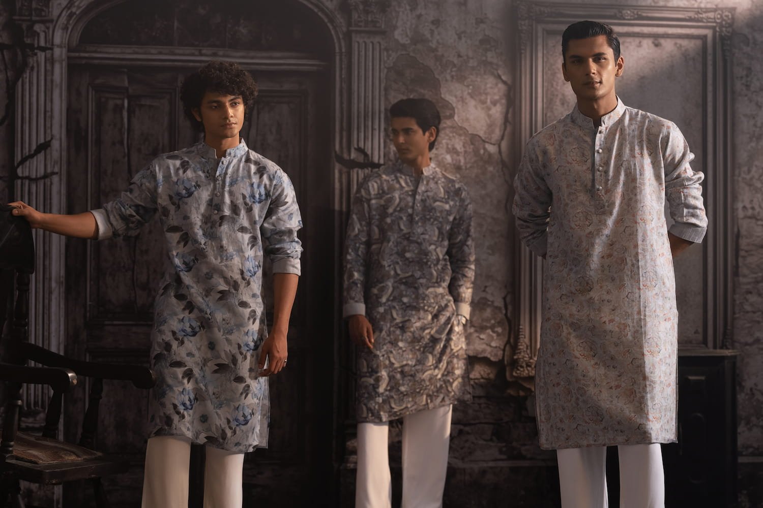 Three models in printed Zihveen panjabis and white pyjamas in an old, ornate room