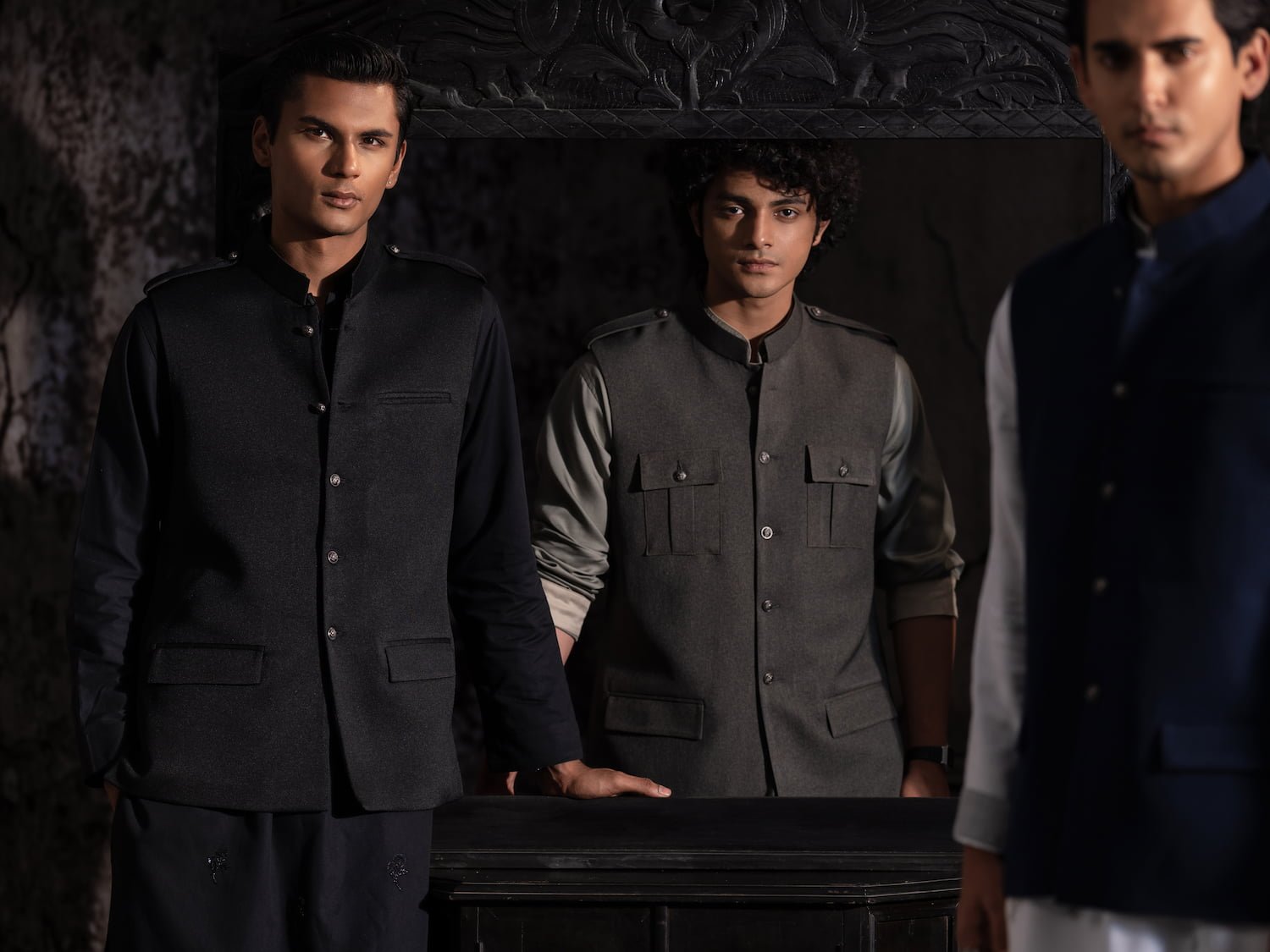 Black and olive military-style vests worn over panjabis